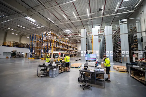 Trabajadores utilizando una computadora para gestionar el inventario de un almacén